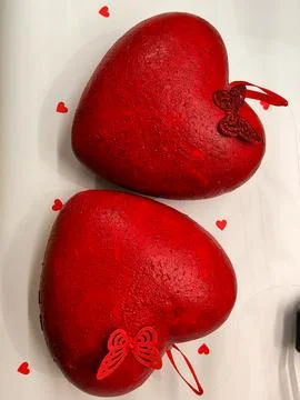 Two red hearts on a beige surface. Stock Photos