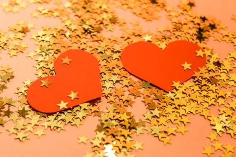 Two red hearts on a golden background with shiny stars Stock Photos