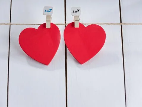 Two red hearts set on string over white background. Stock Photos