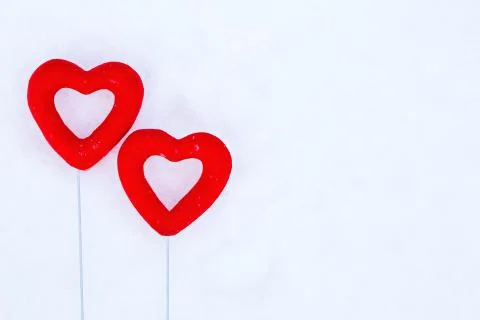 Two red hearts in the snow. Stock Photos