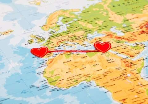 Two red hearts on a world map connected by a red thread Stock-Fotos
