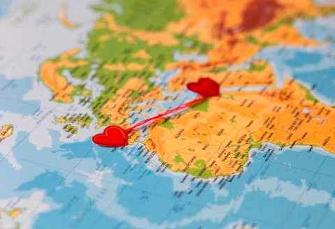 Two red hearts on a world map connected by a red thread Stock Photos