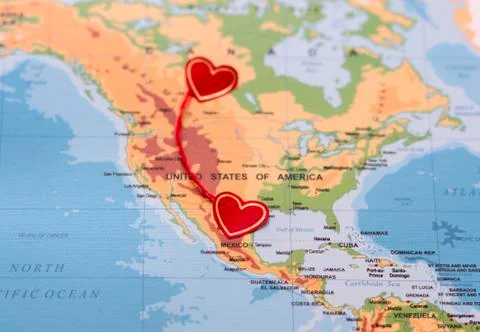 Two red hearts on a world map connected by a red thread Stock Photos