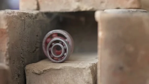 Two red-hot bearings cool down in a brick home-made oven. hot bearings on fir Stock Footage 140323124