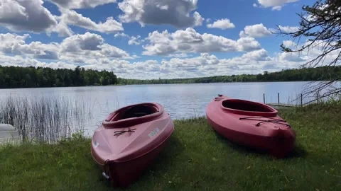 Two Red Kayaks at beach -cumulus clouds timelapse behind Video stock 145155232