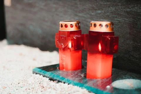 Two red lit candles in front of a marble grave , public cemetary. Stock Photos
