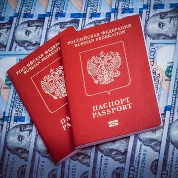 Two red passport on the background of hundred dollar bills. Blue design. Stock Photos