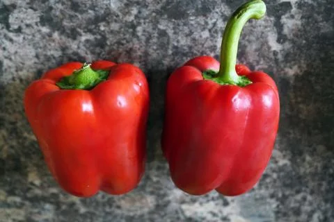 Two red peppers on a kitchen surface 스톡 사진