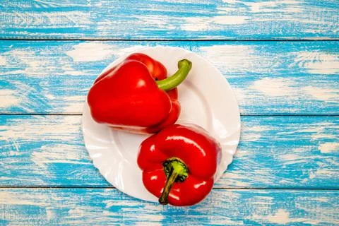 Two red peppers lying on a blue background Stock-Fotos