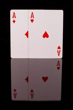 Two red playing aces on a black background with reflection at the bottom Stock Photos