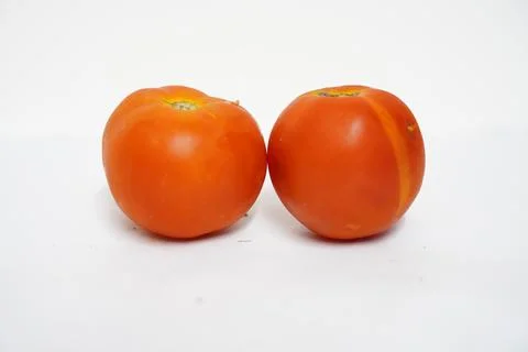 Two Red tomatoes and cherry tomatoes are shown isolated on a white backgroun Stock Photos