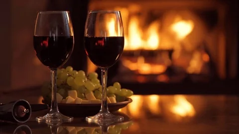 Two red wine wineglasses over fireplace background. Stock Footage 79874393