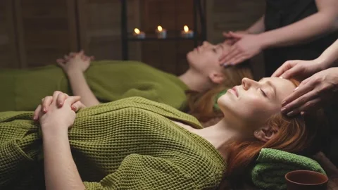Two redhead ladies lie on bed relaxing after spa treatment massage. Stock Footage 150617420