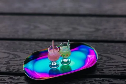 Two refreshing cool and funky cocktails with straws on a colorful, reflective Stock-Fotos