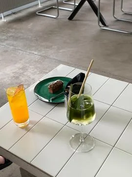Two refreshing drinks and a chocolate dessert on a tiled table at a cafe Stock Photos