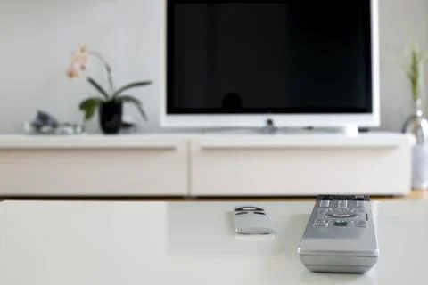 Two remotes on white table for home cinema and entertainment Stock Photos
