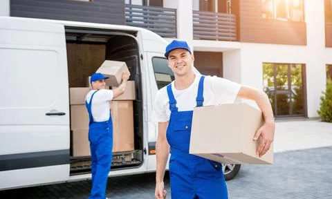 Two removal company workers unloading boxes from minibus into new home Stock Photos