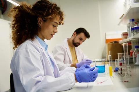 Two researchers testing liquid samples at a laboratory bench 库存照片