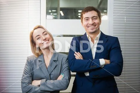 Two respectable business people in formal suits stand together Stock Photos