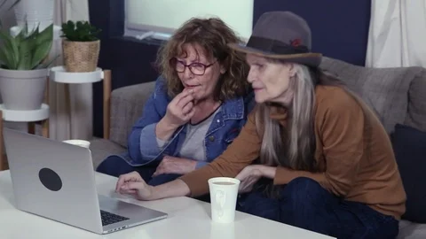 Two retired friends using computer laptop Stock Footage 87896893
