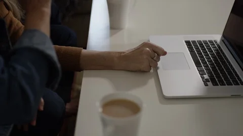 Two retired friends using a laptop computer for social media over coffee Stock Footage 88606004