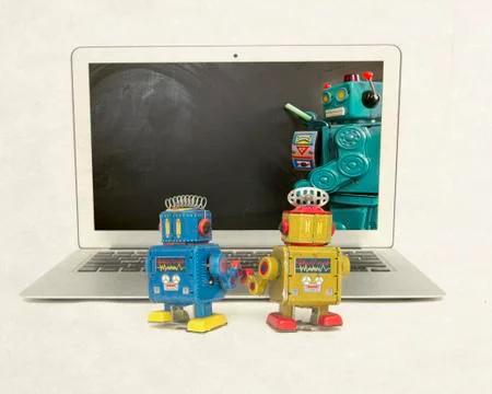 Two retro bobots learn about codeing on a laptop computer Stock Photos