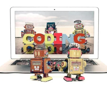 Two retro bobots learn about codeing on a laptop computer i Stock Photos