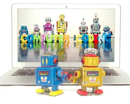 Two retro bobots learn about codeing on a laptop computer i Stock Photos
