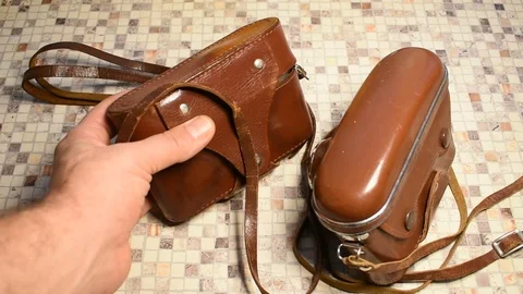 Two retro cameras in cases,  one is taken by a man Stock Footage 122562942