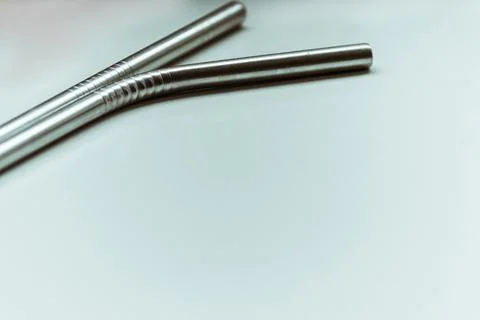 Two reusable cocktail straws lie on a white background with plenty of space. Stock Photos