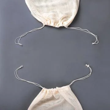 Two reusable string bags for different products on the grey background. Stock Photos