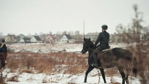 Two riders practice riding in snowy countryside. Pair of individuals engaged in Stock Footage 345177589