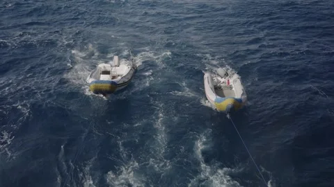 Two rigid inflatable boats floating and being pulled through the choppy waters Stock-Footage 333848784