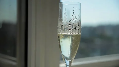 Two rings fall into a glass of champagne, making sparkling bubbles. Stock Footage 142737159