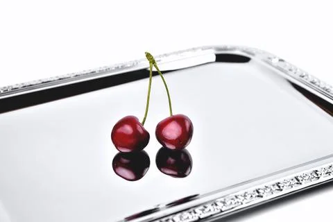 Two ripe cherries on a mirror surface Stock Photos
