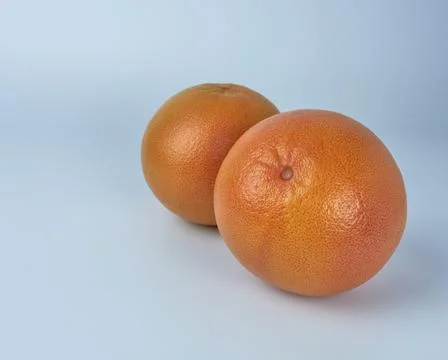 Two ripe grapefruits on a white background, close-up. Stock Photos