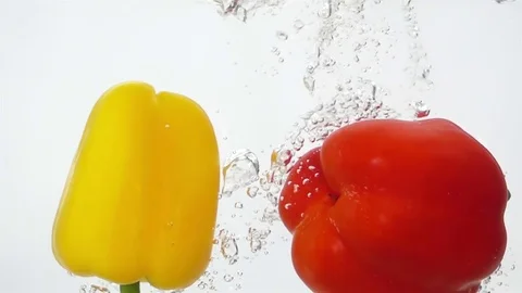 Two Ripe Peppers Falling Through Water. Stock Footage 73551585