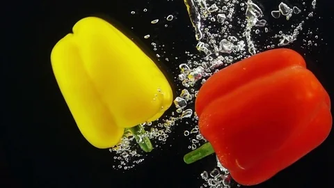 Two Ripe Peppers Falling Through Water. Stock Footage 73570576