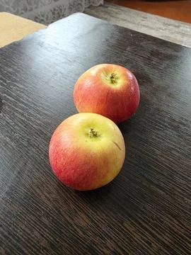 Two ripe red apples on dark wooden table Stock Photos