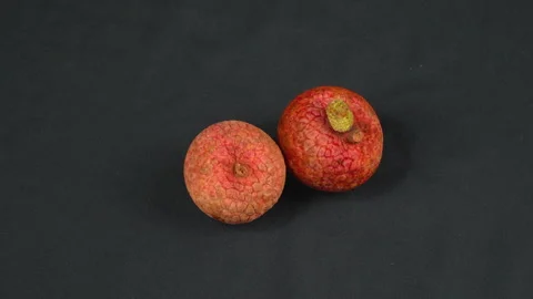 Two Ripe Red Lychee Fruits Rotating on Dark Black Background Stock Footage 337326906