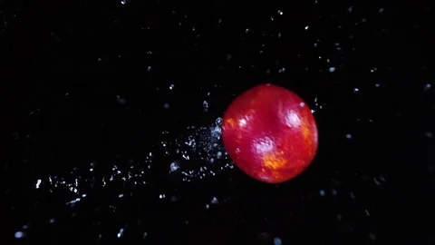 Two ripe red oranges falling and splashing in extreme slow motion Stock Footage