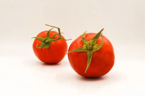 Two ripe red tomatoes positioned in a diagonal depth-of-field arrangement Stock Photos
