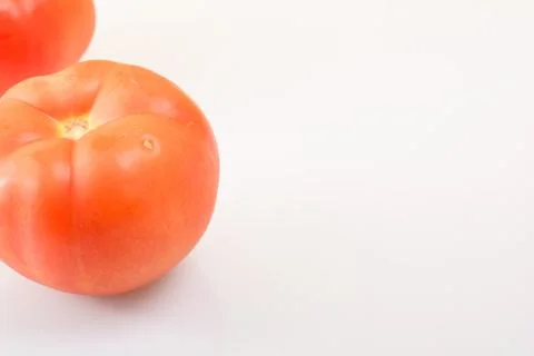 Two ripe tomatoes on a light background propped up Stock Photos