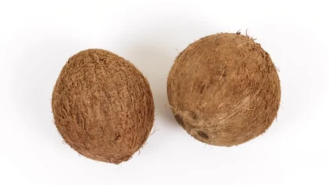 Two ripe whole tropical coconuts rotating on white background. Tropical fruits Video stock 86875067