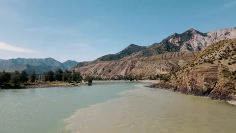 Two rivers collide into one with amazing mountain view. Drone footage Stock Footage 166067742