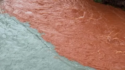 Two rivers with different colors flowing together without mixing. Natural Stock Footage 327631256