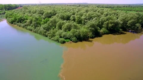 Two rivers of different colors of water merge into one large river. Aerial View Stock Footage