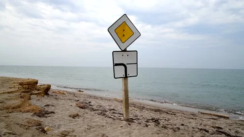 Two road signs indicating the direction of the main road stand on the shore of Stock Footage 166702728