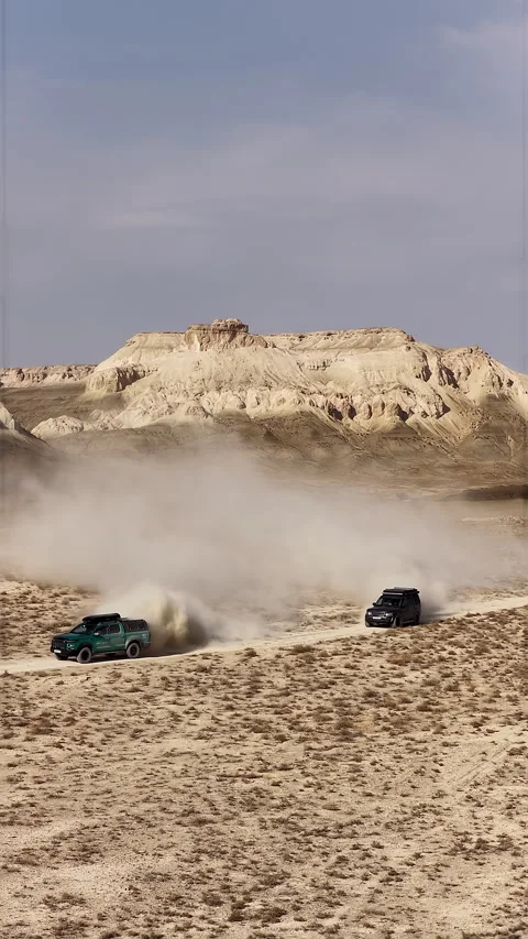 Two off-road vehicles racing in a dusty desert landscape, Bozjyra, Mangystau Stock Footage 322804322