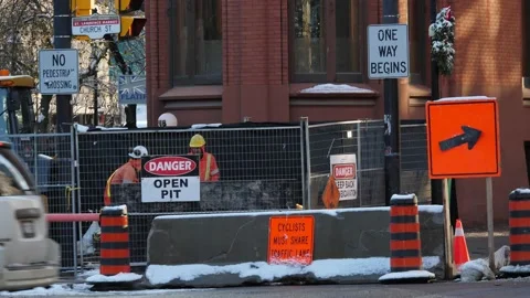 Two Roadmen Working in Dangerous Open Pit in Toronto City Gooderham Building 库存影片 149220284